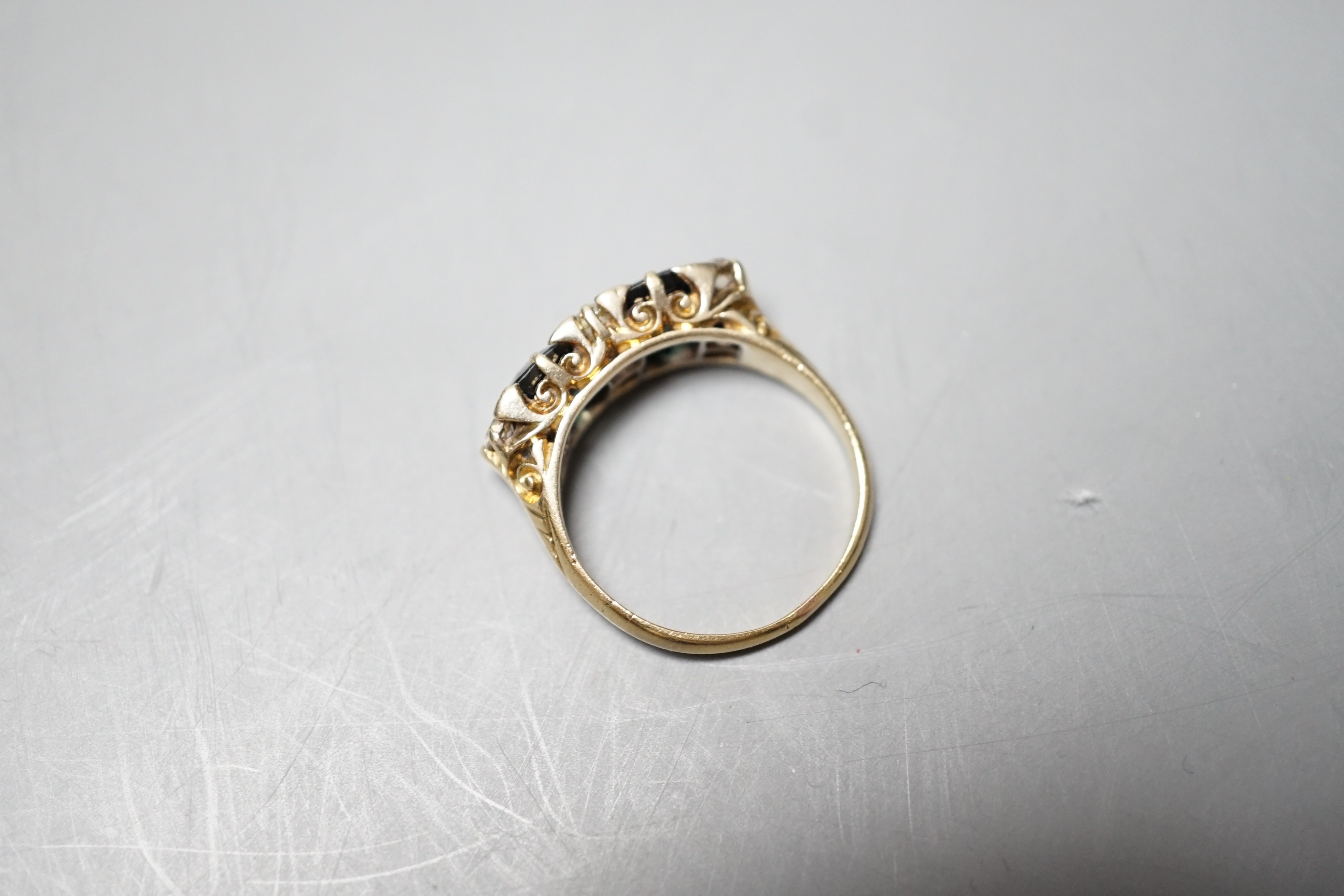 A yellow metal and two stone oval cut blue/green sapphire and seven stone diamond chip set half hoop dress ring, size Q, gross weight 5.7 grams